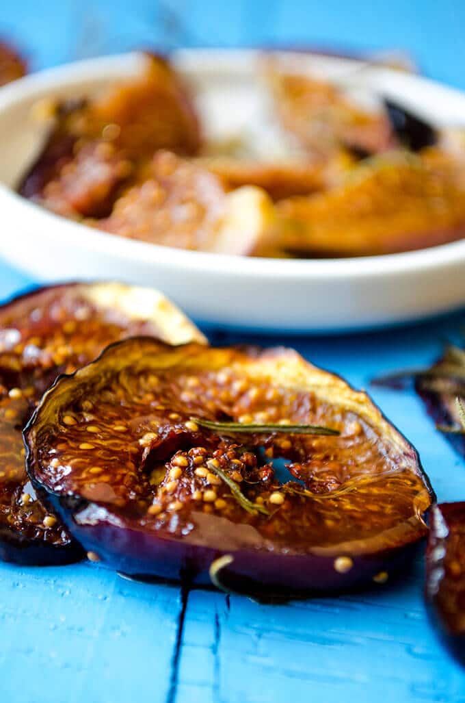 An easy fig dessert with black figs and rosemary on a blue background