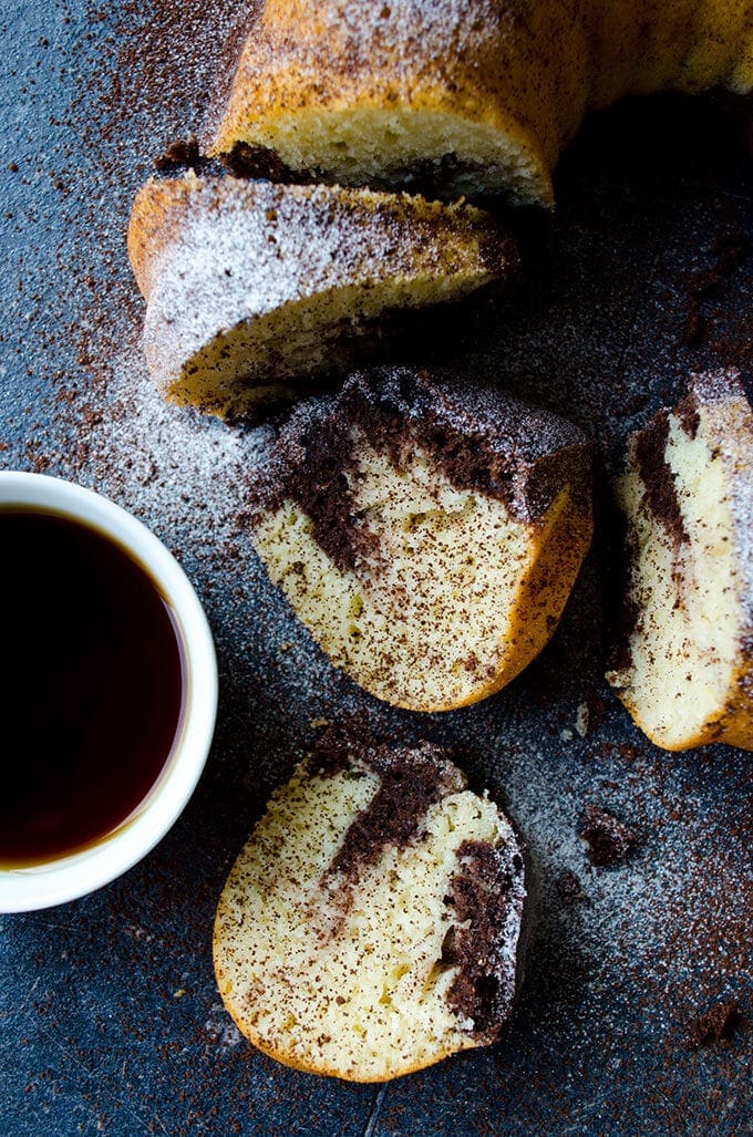 Yogurt Bundt Cake with a chocolate swirl sliced on a dark backdrop