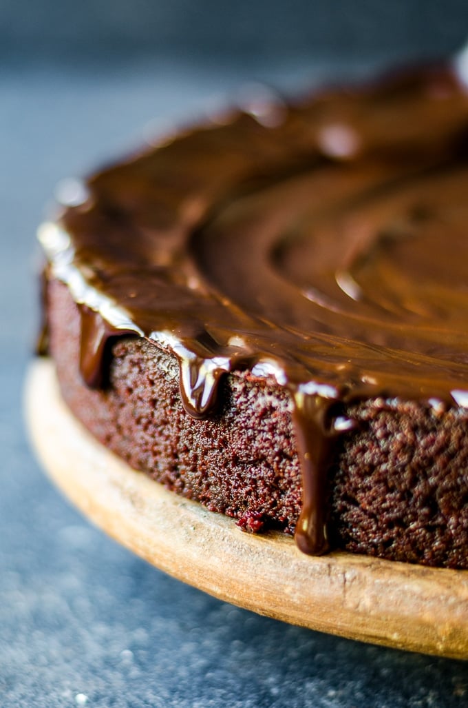 Beet cake with chocolate ganache on a cake stand.