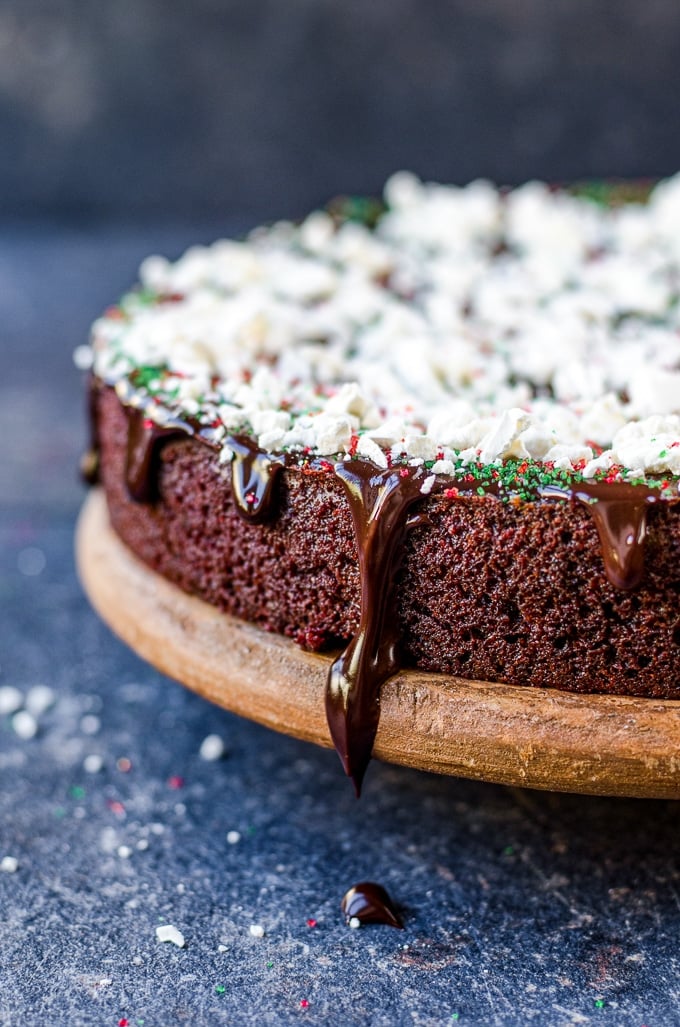 Chocolate beet cake with sprinkles and crumbled meringue on a cake stand.