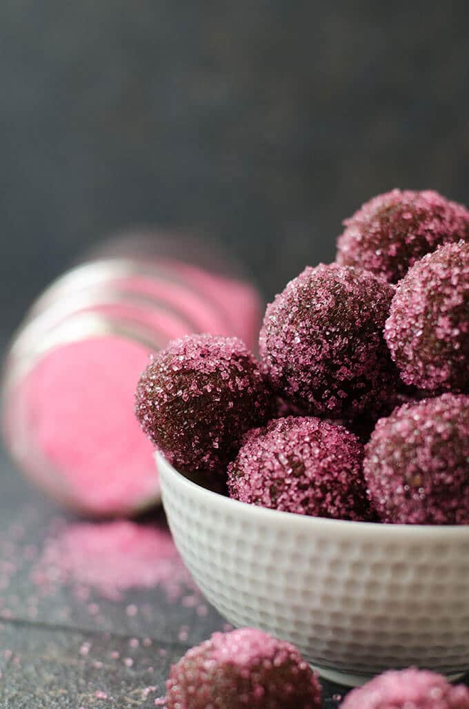 Homemade truffles with ganache and biscuits in a white bowl on a dark background.