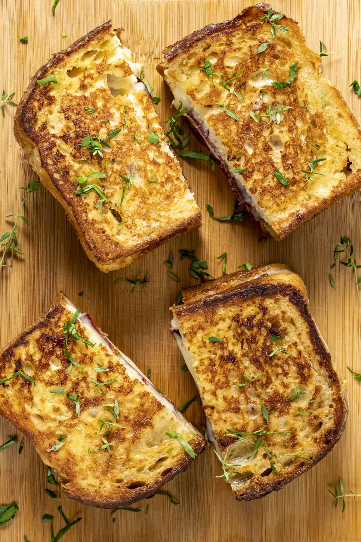 Four pieces of sanddwiched French toasts on a wooden board.