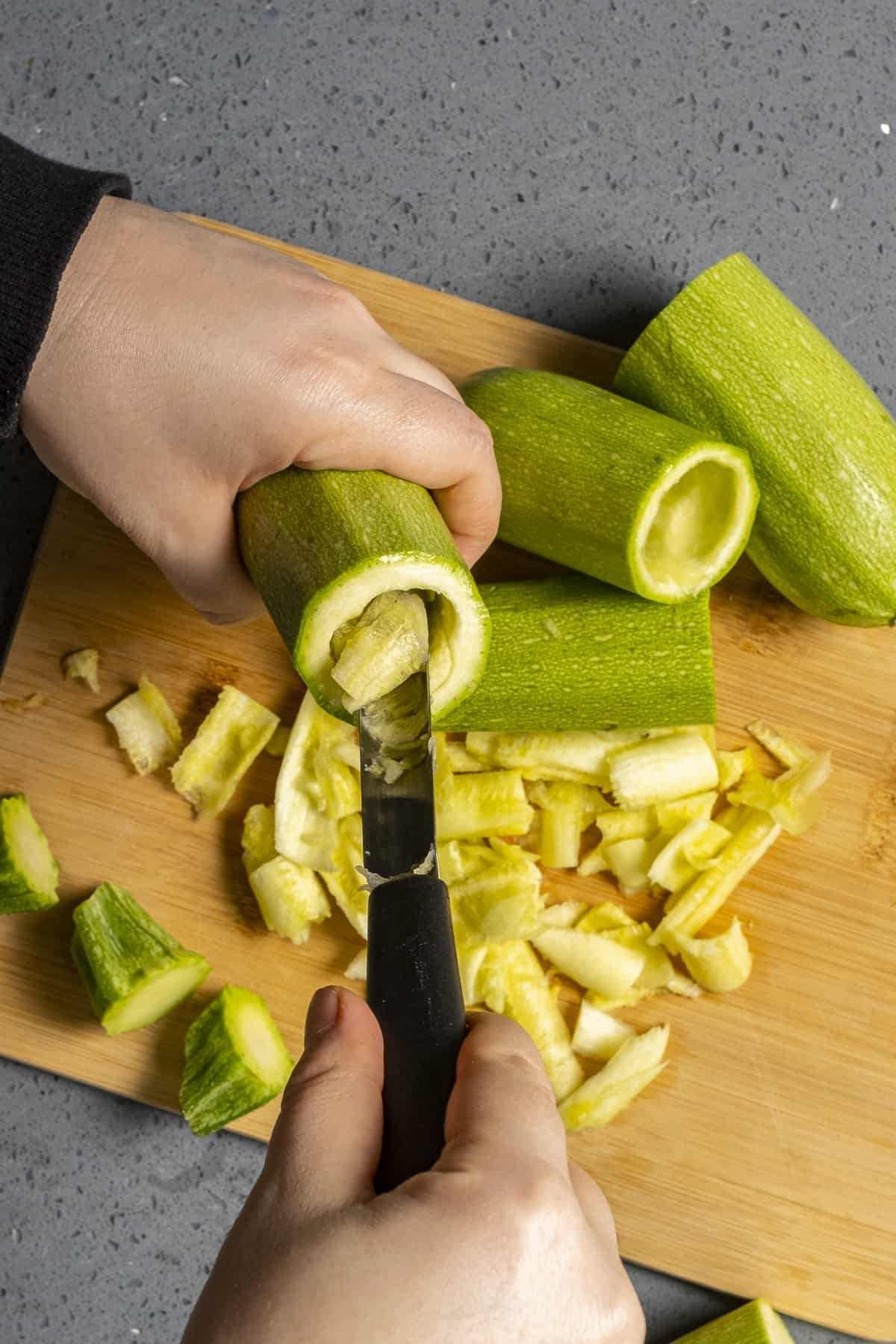 Zucchini being cored with a corer.