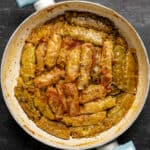 Turkish cabbage rolls with tomato sauce in a white pan.