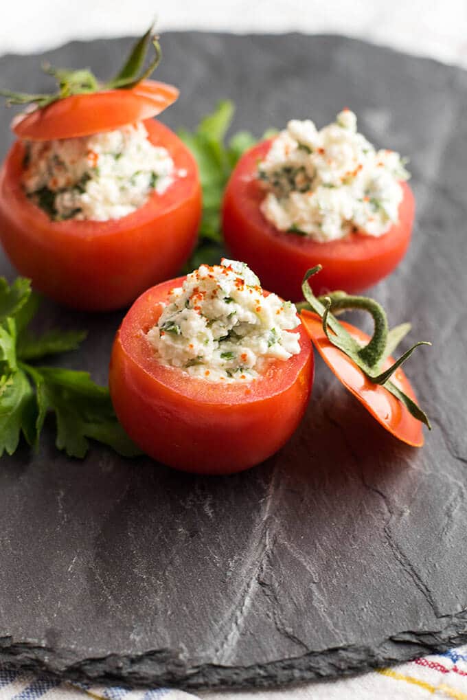 Looking for the easiest appetizer recipe ever? Make these Cheese Stuffed Tomatoes with 6 simple ingredients. No need for cooking or baking. Ready in 5 minutes! #stuffedtomatoes #appetizer Cheese Stuffed Tomatoes served on a black stone