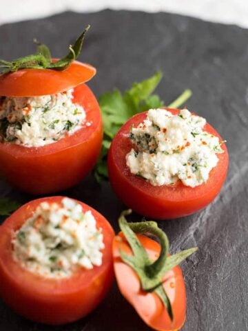 Cheese Stuffed Tomatoes served on a black stone