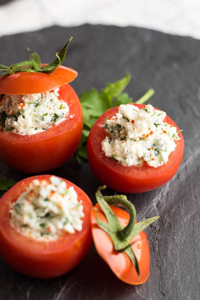 Looking for the easiest appetizer recipe ever? Make these Cheese Stuffed Tomatoes with 6 simple ingredients. No need for cooking or baking. Ready in 5 minutes! #stuffedtomatoes #appetizer Cheese Stuffed Tomatoes served on a black stone