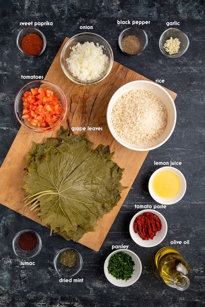 Ingredients for stuffed grape leaves on a dark background.