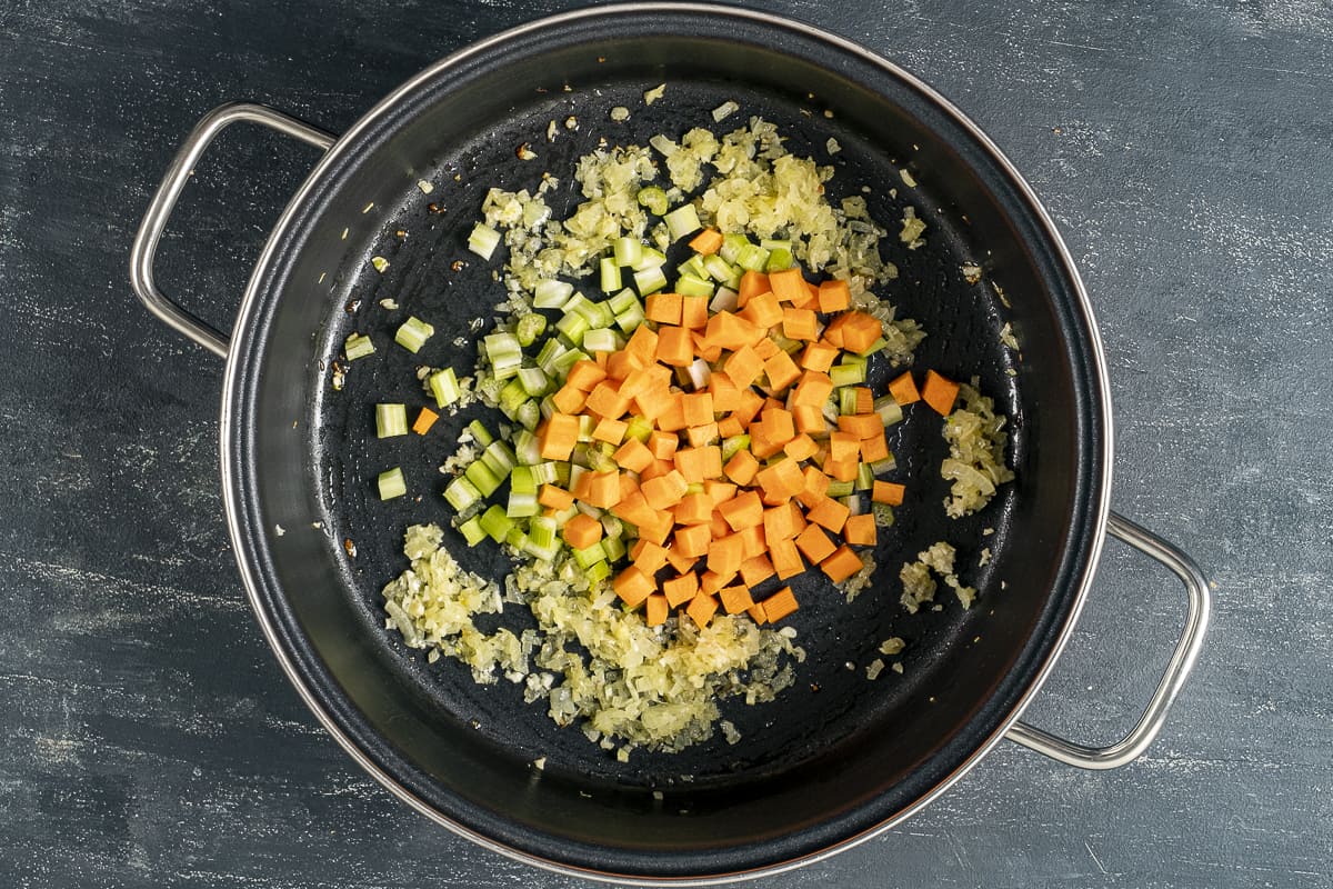 Onions, carrots and celery in a pan.