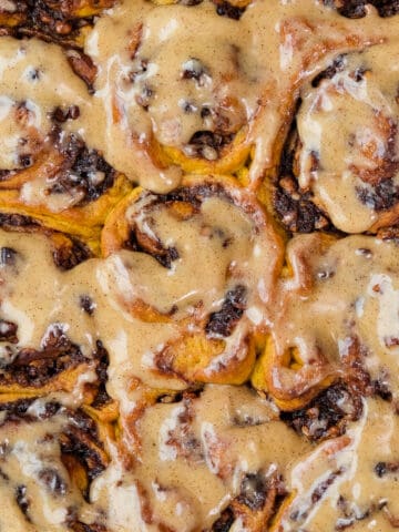 Close shot of cinnamon rolls with a spiced vanilla frosting.