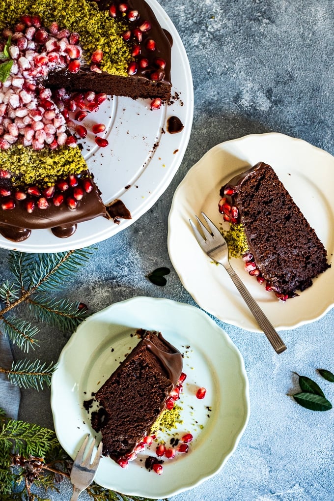 Greek yogurt chocolate cake on a stand and slices on two plates.