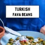 Person adding yogurt to a bowl of Turkish-style fava beans in pods, garnished with dill.