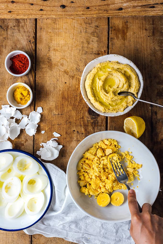 Making a healthy deviled eggs recipe with hummus and turmeric.