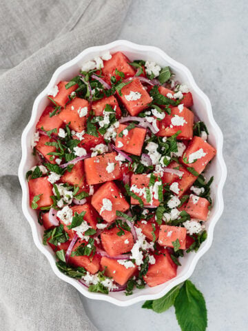 Watermelon Feta Mint Salad with red onion is a super refreshing summertime recipe. The simple balsamic dressing in this unexpected combination of flavors takes the salad to the next level.