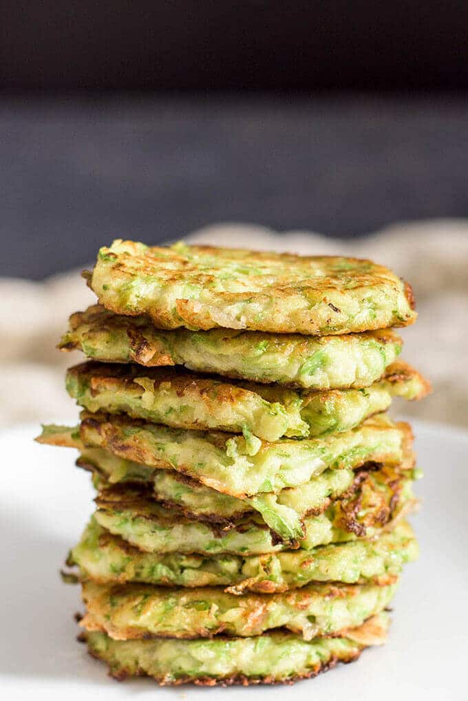 A great list of gluten free zucchini recipes from dinners to appetizers. These are so good that you don't need to follow a gf diet to make them. #zucchinirecipes #zucchini #glutenfree A stack of gluten free zucchini fritters