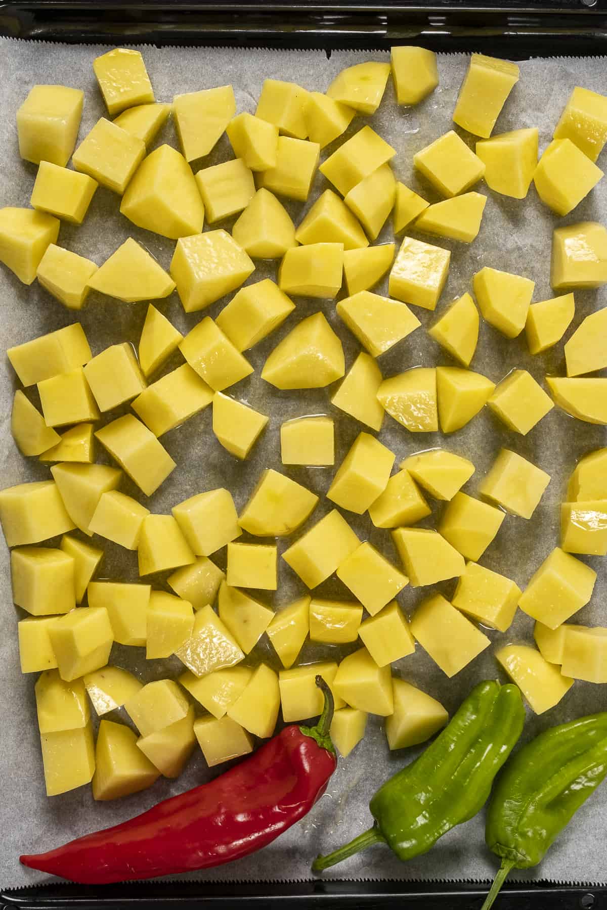 Chopped potatoes on a baking sheet lined with baking paper.