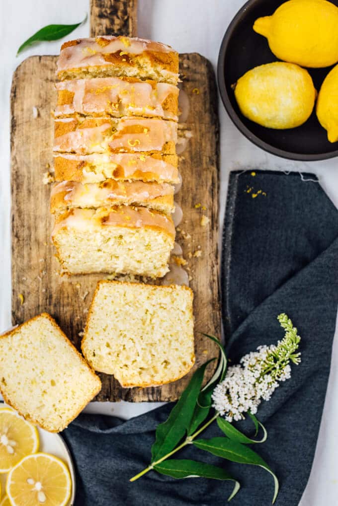 Glazed lemon zucchini bread sliced on a wooden cutting board