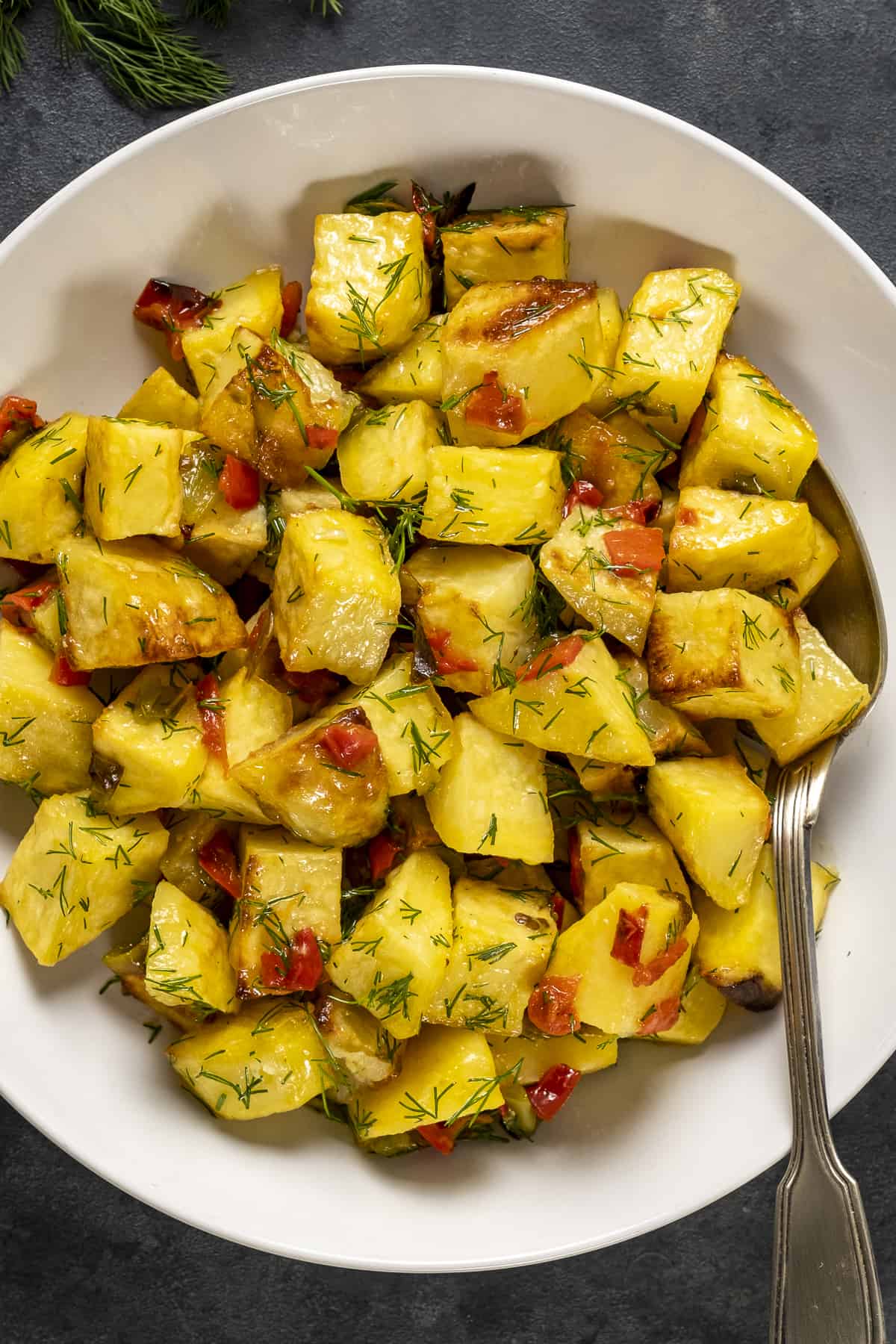 Chopped roasted lemon potatoes in a white bowl.