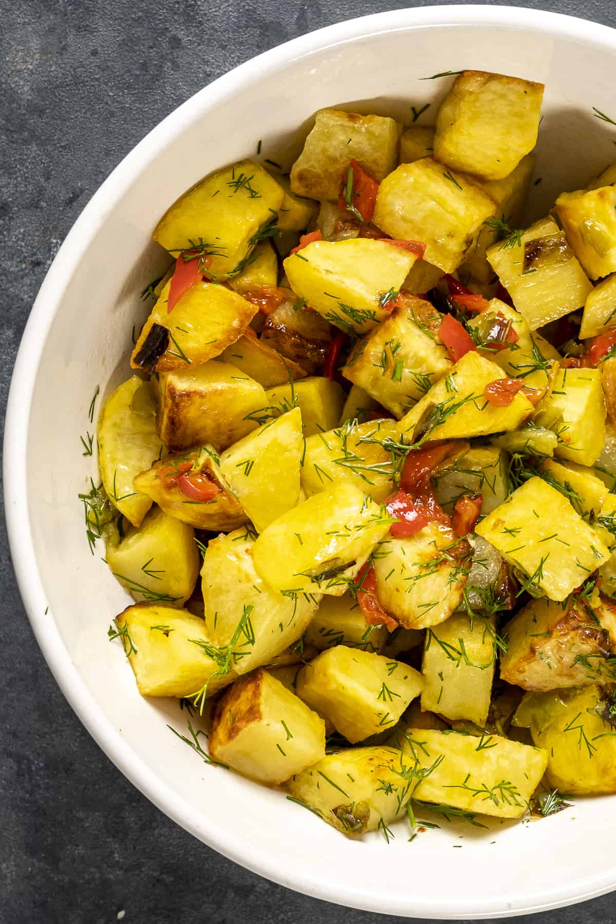 Roasted lemon potatoes with peppers in a white bowl.