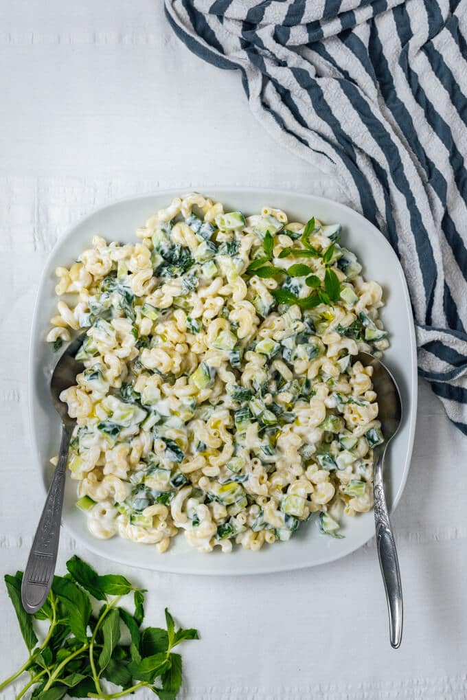 Cucumber pasta salad without mayo in a white bowl with spoons