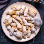 Turkish apple cookies dusted with powdered sugar on a plate.