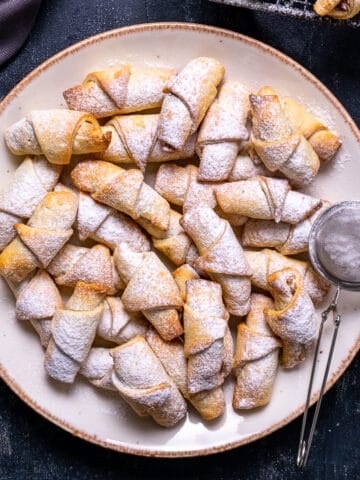 Turkish apple cookies dusted with powdered sugar on a plate.