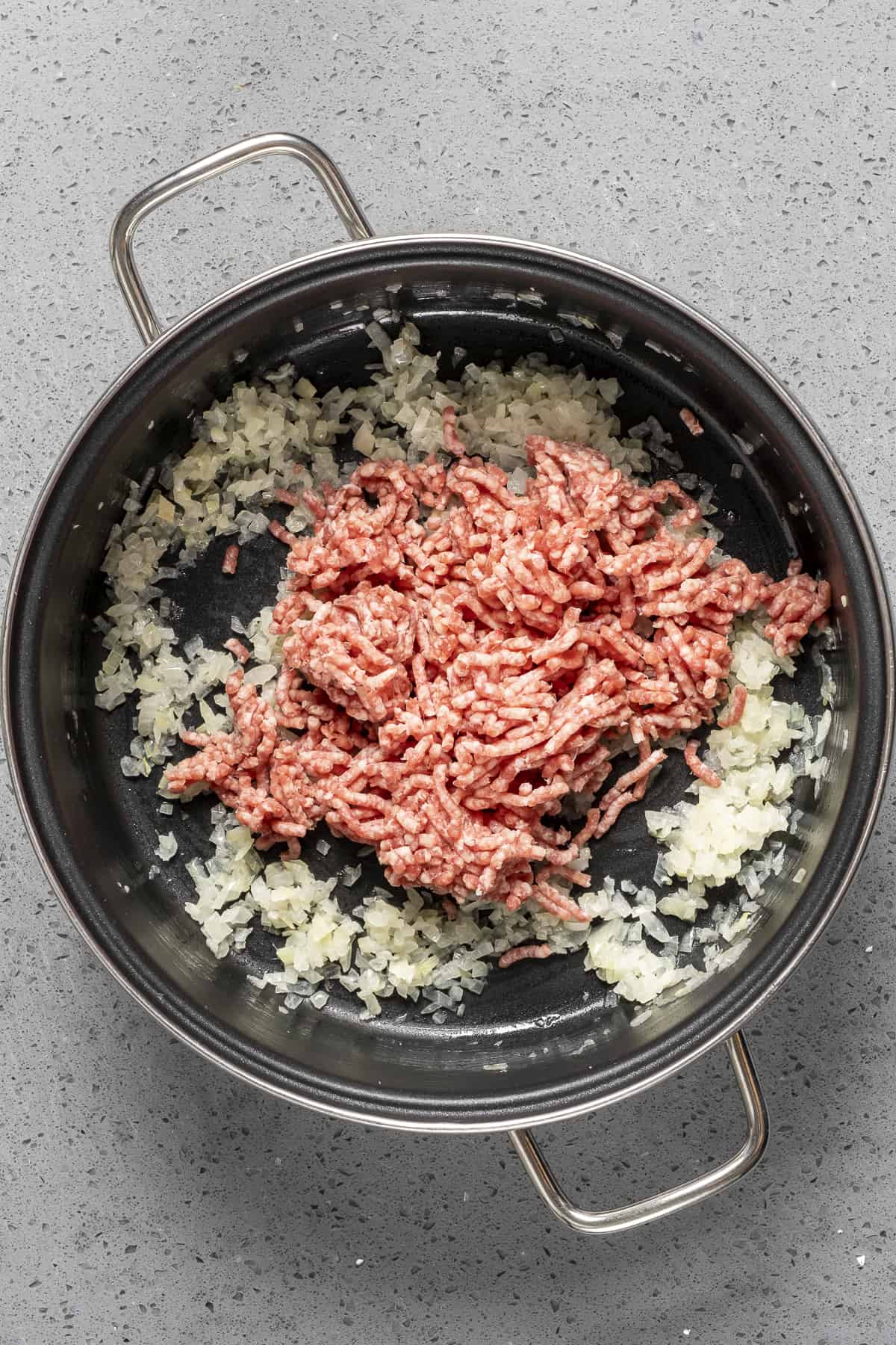 Ground beef and onions cooking in a pt.