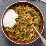 Cabbage roll soup in a bowl garnished with parsley and a little yogurt.