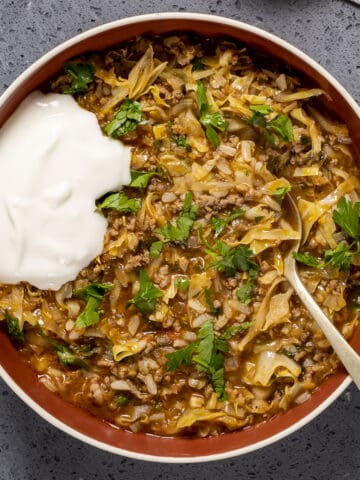 Cabbage roll soup in a bowl garnished with parsley and a little yogurt.