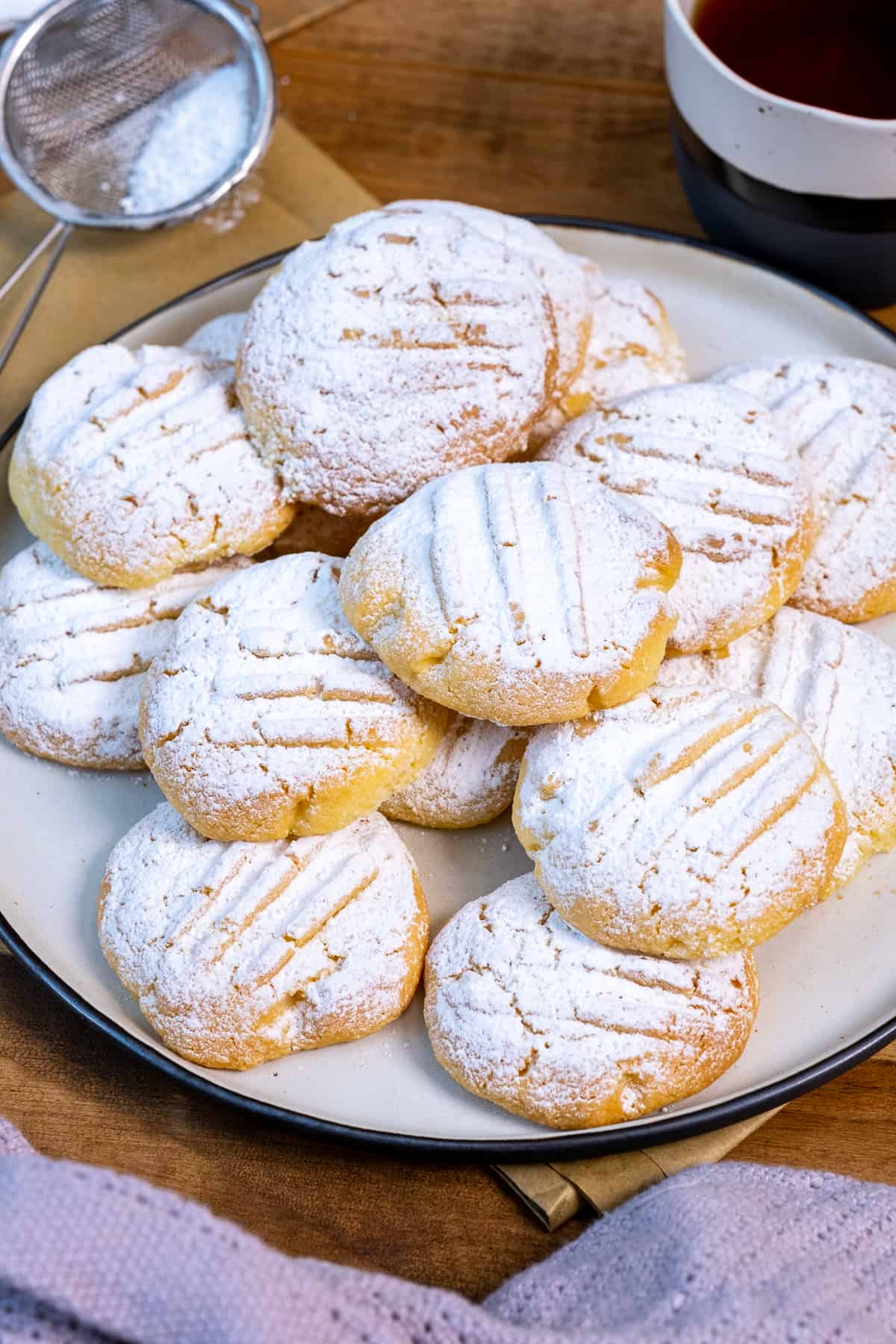 Cornstarch cookies topped with powdered sugar on a plate.