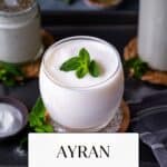 Yogurt drink in a glass, garnished with mint leaves.