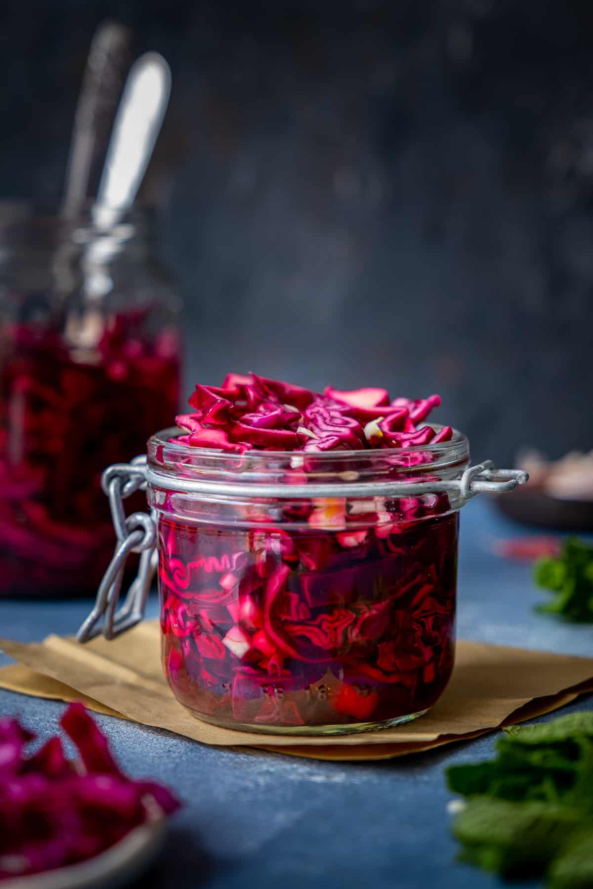 Red cabbage pickle in a jar on a dark background.