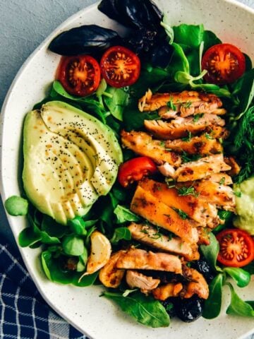 Keto chicken salad with avocado and herbs in a ceramic bowl