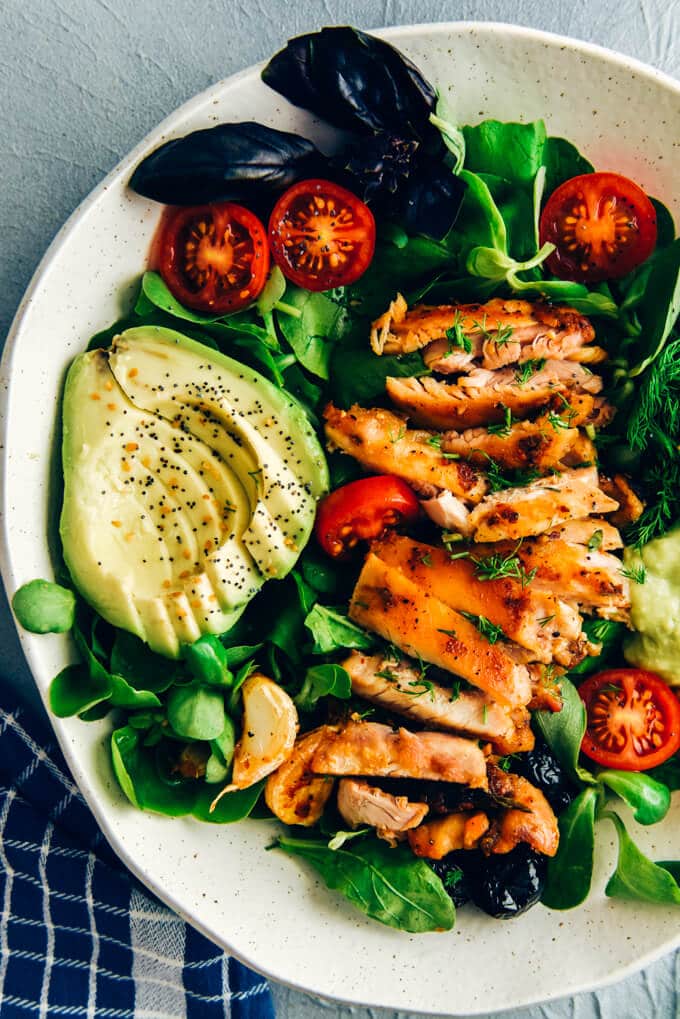 Keto chicken salad with avocado and herbs in a ceramic bowl