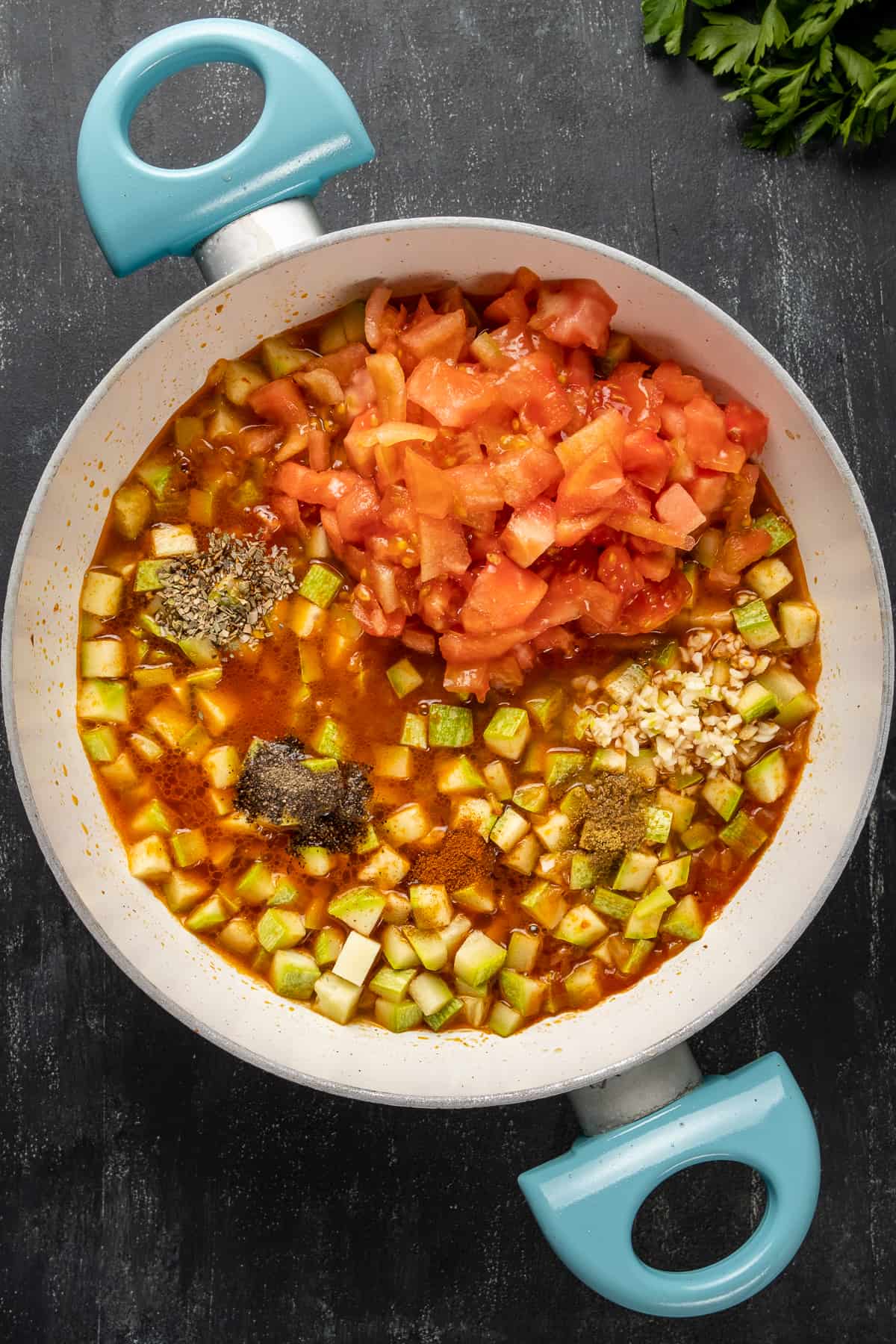 Diced zucchini, tomato sauce, chopped tomatoes, garlic and spices in a pan.