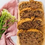 best vegan zucchini bread slices on a wooden board with flowers