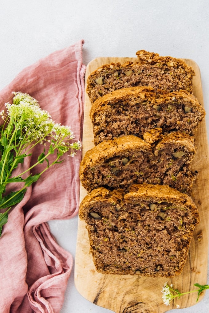 best vegan zucchini bread slices on a wooden board with flowers