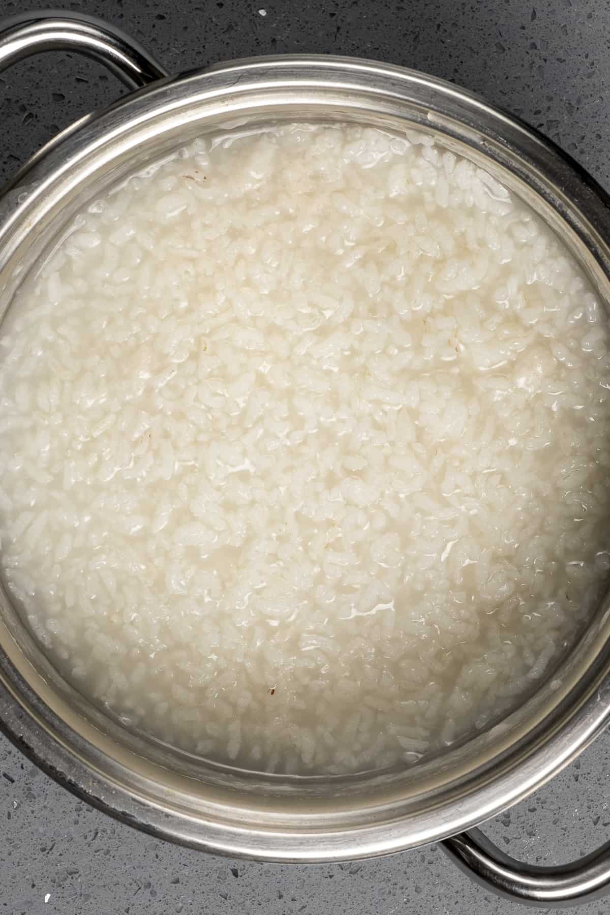 Creamy cooked rice with a little water in a pan.