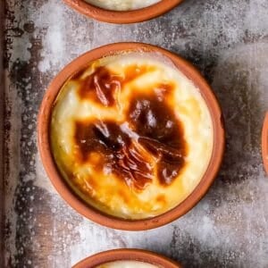 Close-up of Turkish rice pudding (sütlaç) with a beautifully caramelized top in a traditional clay bowl.