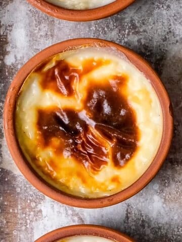 Close-up of Turkish rice pudding (sütlaç) with a beautifully caramelized top in a traditional clay bowl.