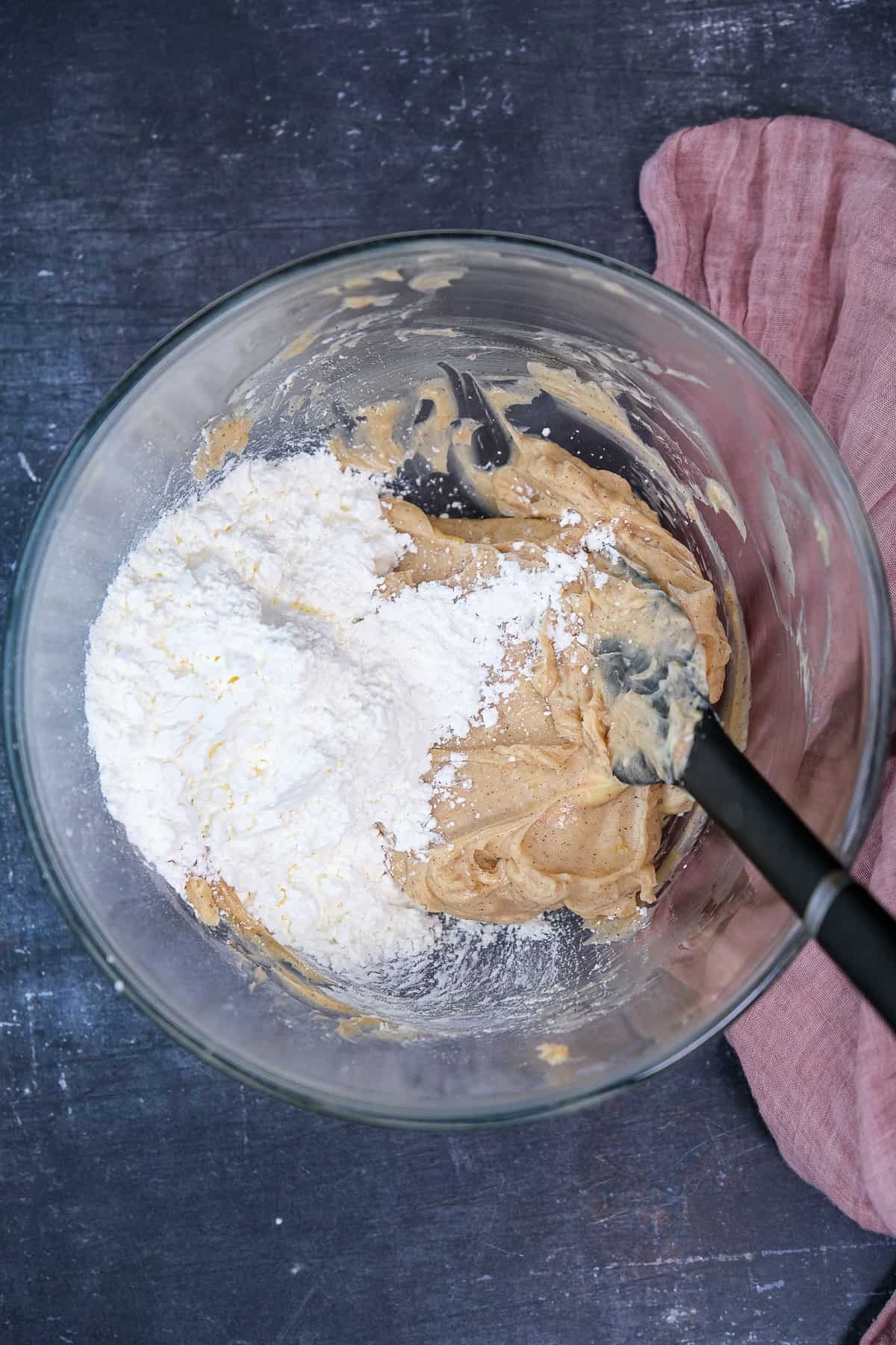 Cornstarch is being mixed with the other ingredients in a glass mixing bowl and a spatula inside it.