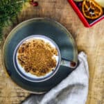 Salep drink topped with cinnamon in a cup on a wooden background.