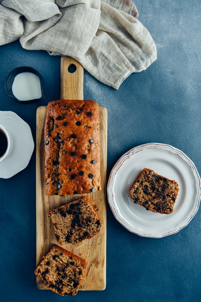 Chocolate chip banana bread sliced on a wooden cutting board.