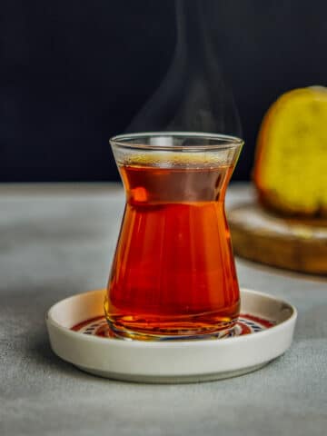 Hot Turkish tea in its traditional tea glass and saucer.