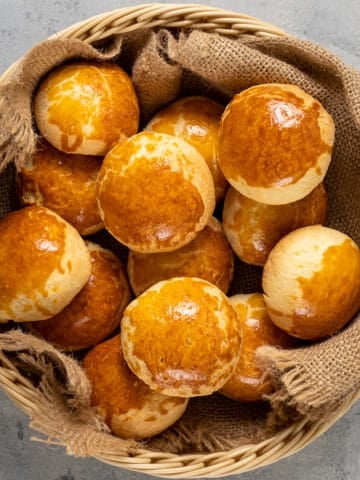 Homemade rolls with golden top in a basket shot from top view.