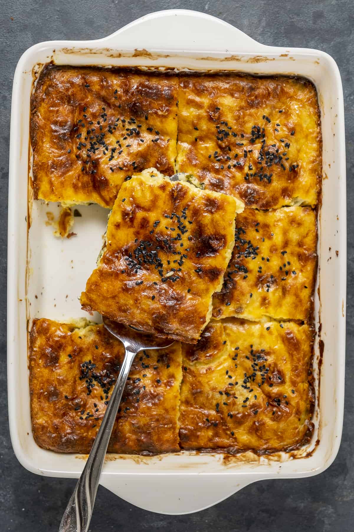 Spinach borek cut into squares in a baking pan.