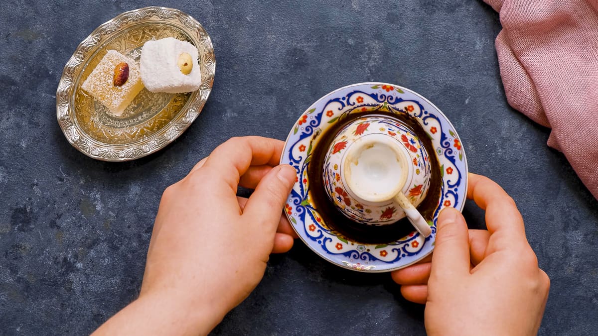 Hands turning the coffee cup upside down.