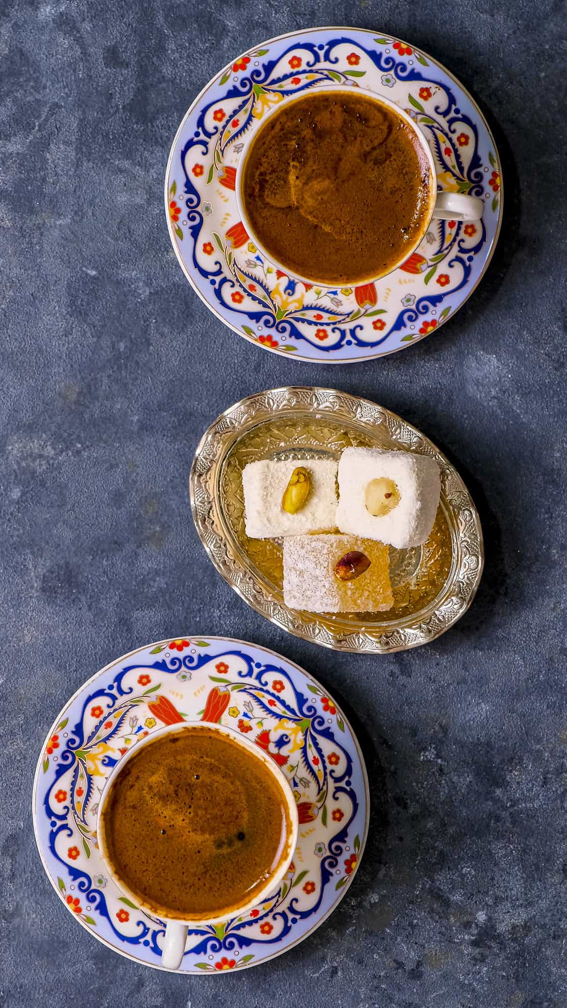 Two cups of Turkish coffee accompanied by Turkish delights.