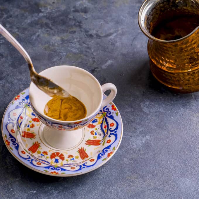Pouring coffee foams into traditional Turkish cups.