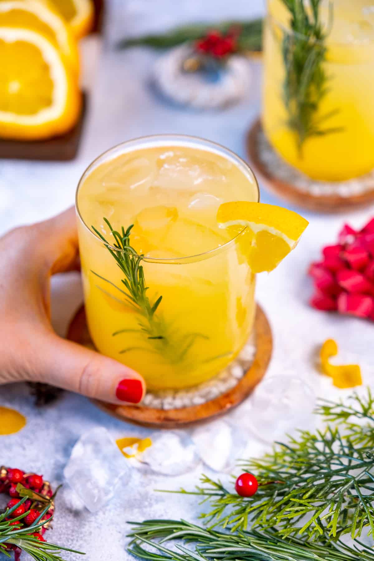 A hand holding a glass of vodka orange cocktail.